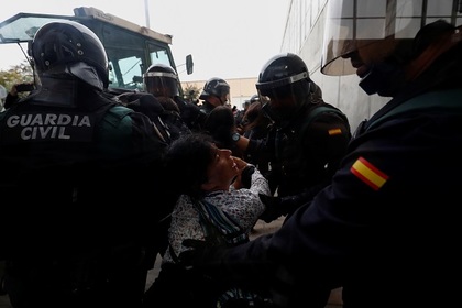 Полиция начала силой выводить голосующих с участков в Каталонии