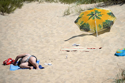 Летящий по ветру зонт пронзил гулявшую по пляжу женщину