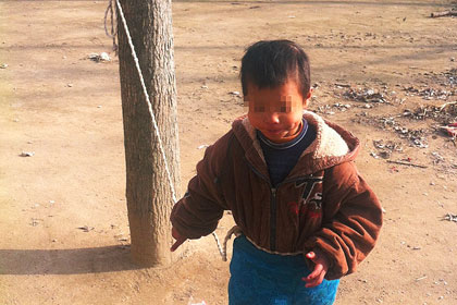 Умственно отсталого ребенка в Китае привязали к дереву